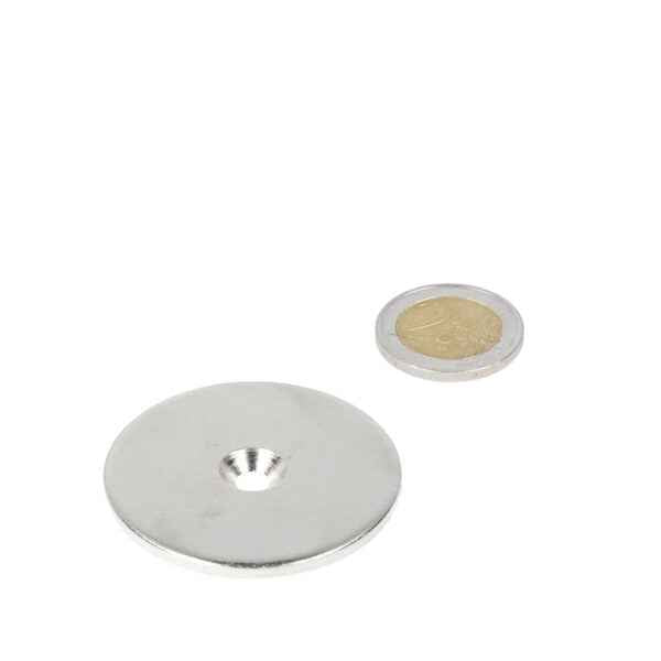 Zilverkleurige ring van staal met boor- verzinkgat 48 x 11 x 5,5 x 3 mm naast munt voor diverse toepassingen