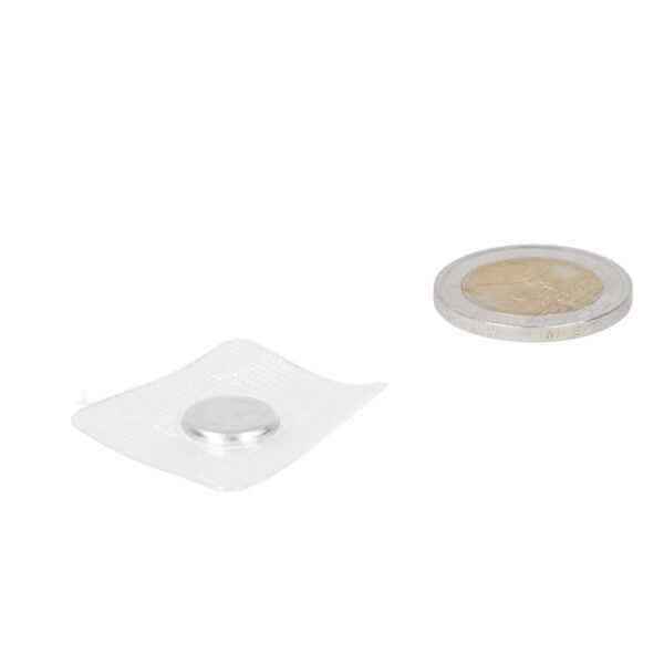 Zilverkleurige ronde button batterij naast een munt voor schaal bij naaimgneet met pvc 12 x 2 mm met sterke grip