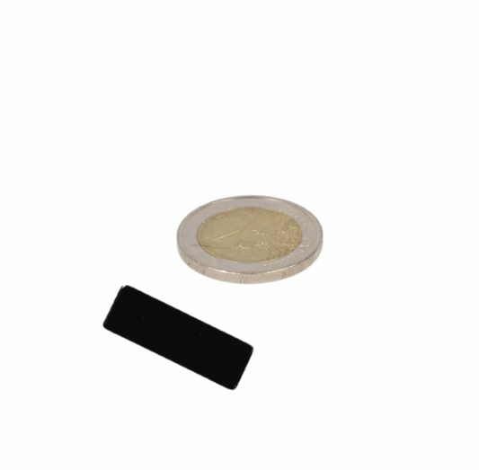 Zwarte neodymium blokmagneet 30x10x2,5 mm n48 epoxy gecoat naast euromunt voor industriële toepassingen