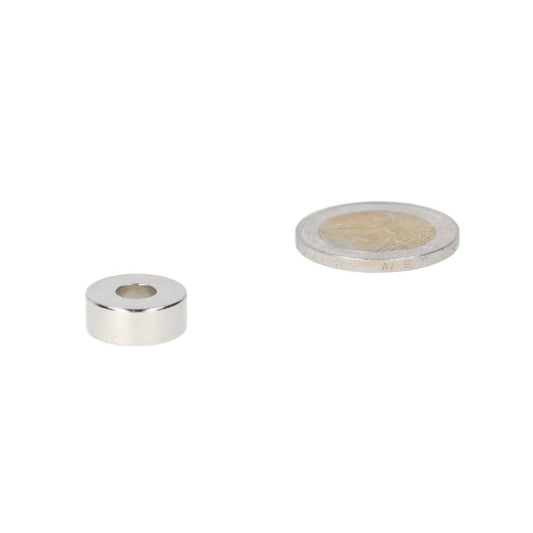 Ringmagneet 15 x 6 x 6 mm zilverkleurige neodymium cilinder met centrale opening naast munt voor magnetische kracht en diverse toepassingen