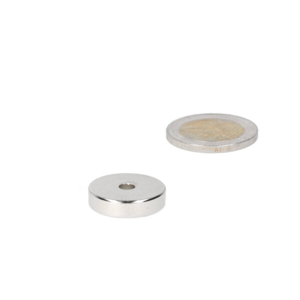 Zilverkleurige ringmagneet 20 x 4,2 x 5 mm met sterke aantrekkingskracht naast een munt voor verschillende projecten